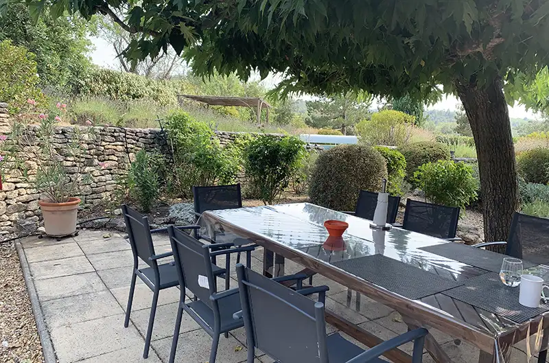 Terrasse du gîte plein sud ombragée par un pin